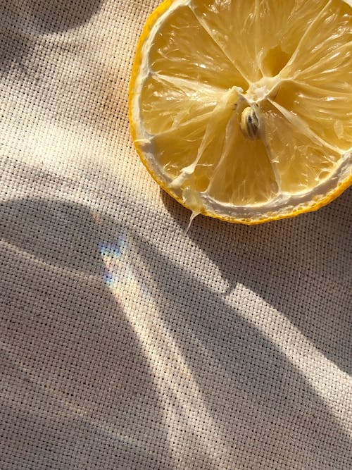 Free Close-up of a Slice of Lemon Lying on a Cloth in Sunlight  Stock Photo