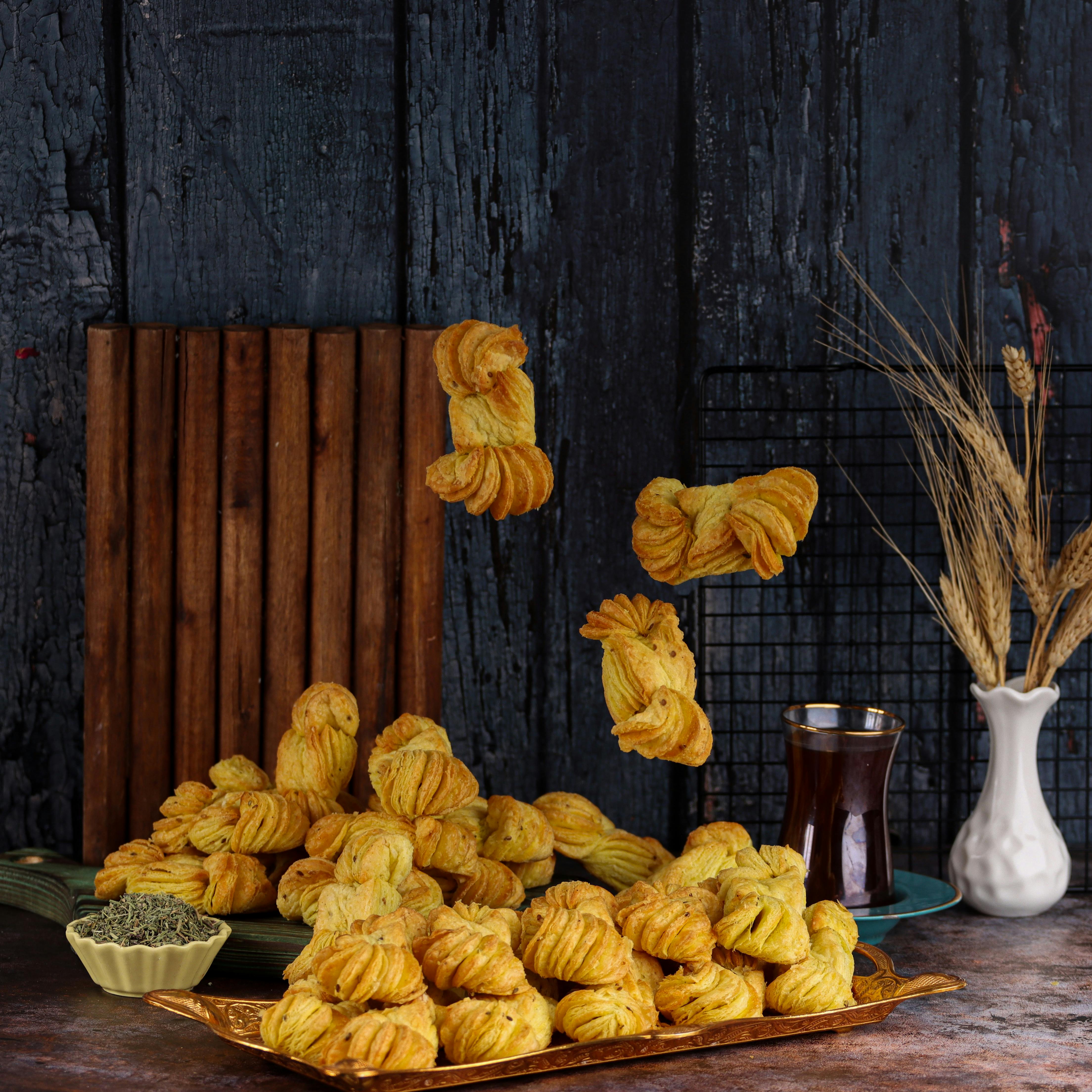 Savory pastries on a vintage tray with tea and rustic decor, perfect for food lovers.