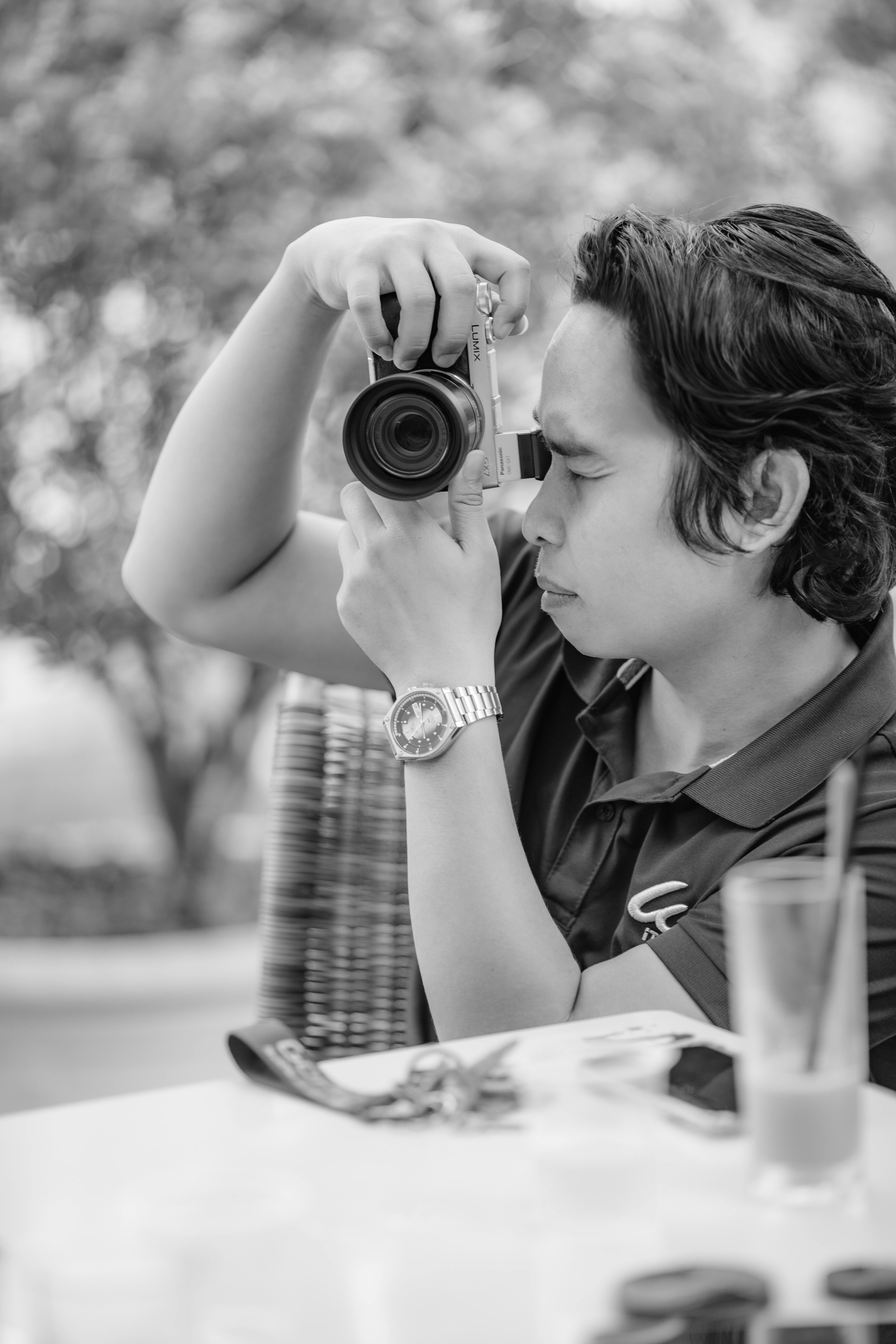 Free Black and white image of a man taking photos outside with a camera. Stock Photo