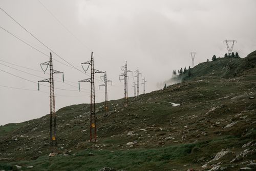 Free Moody landscape with power lines in a foggy mountain setting, creating a dramatic ambiance. Stock Photo