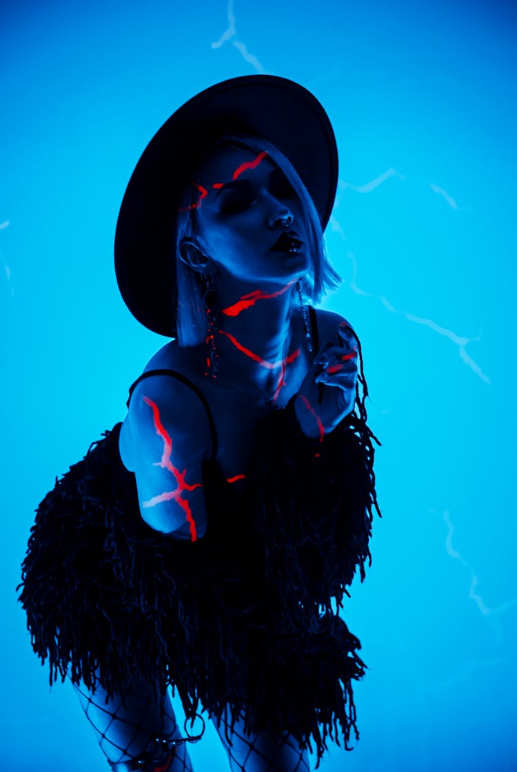 Silhouette Of Woman In Hat Dancing On Blue Background