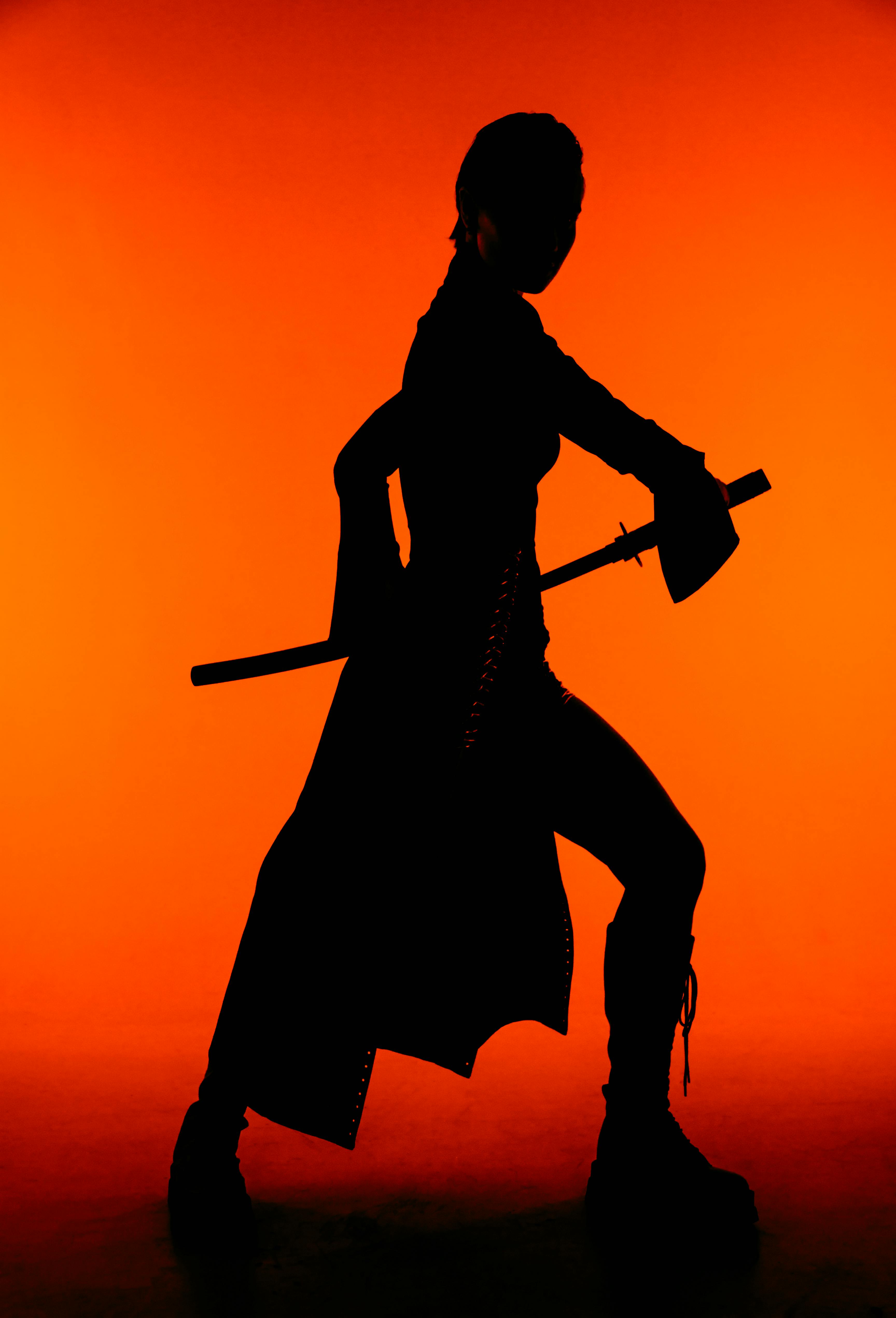 silhouette of woman in costume with sword