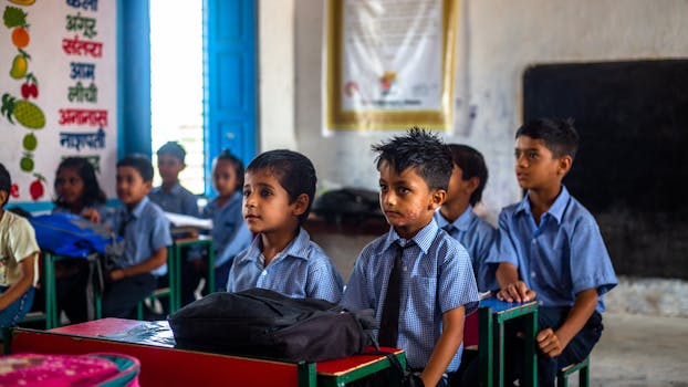 Indian school children in uniforms attentively listening in class.