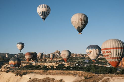 Free Beautiful hot air balloons floating over Cappadocia's unique rock formations in Türkiye. Stock Photo