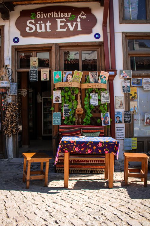 Free Colorful and cozy street cafe entrance in Sivrihisar, Türkiye with vibrant decor and wooden furniture. Stock Photo