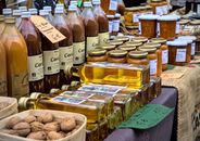 Fresh organic juices, oils, and preserves displayed at a vibrant French market stall.