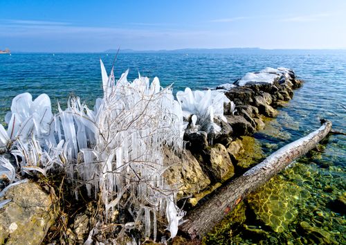 Free Frozen landscape of a rocky causeway leading into a serene ocean in winter. Stock Photo