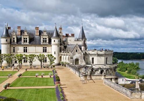 Majestic view of Château Royal d'Amboise and its gardens under a cloudy sky in France.