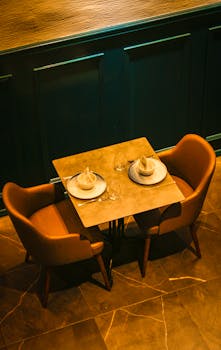 A stylish dining setup with two contemporary chairs and tableware in a modern restaurant.