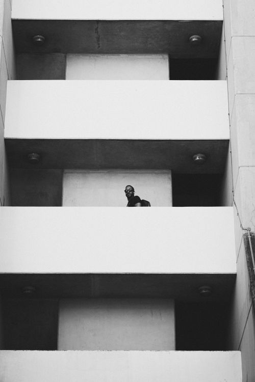Free A man stands on a building balcony, London, captured in monochrome. Stock Photo