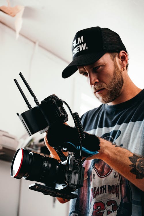 A man with a hat and gloves holding a camera