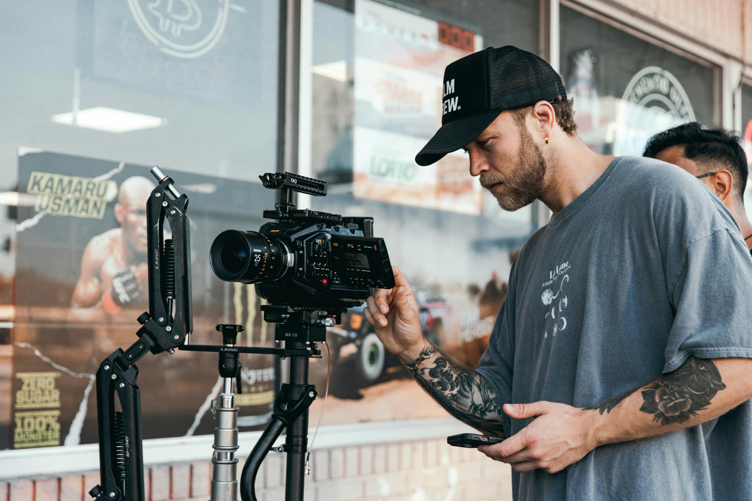 A man holding a camera and a tripod · Free Stock Photo