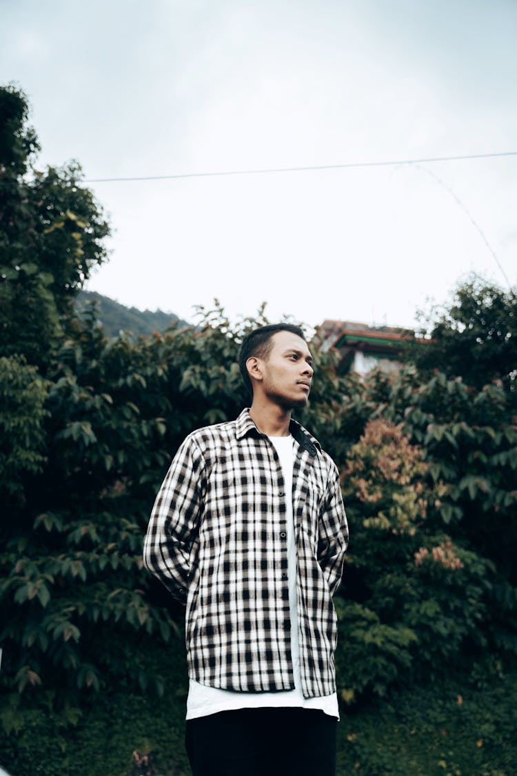 Man In Checked Shirt Standing By Tree