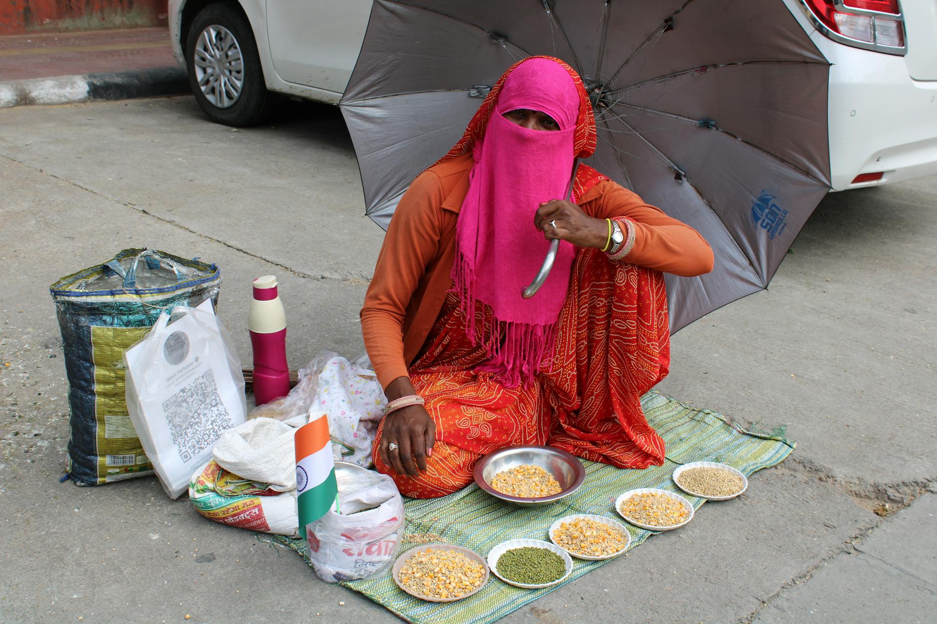 Indian street vendor in Jaipur offering grains under an umbrella with QR code payment option.