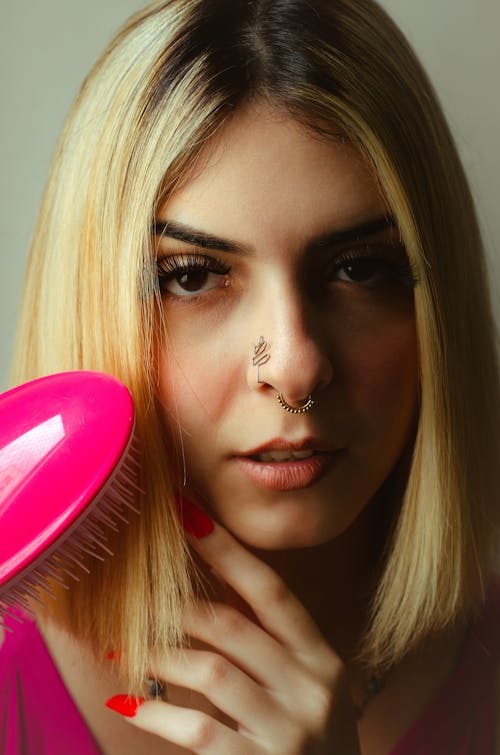 Blonde Woman with Piercing Combing Hair