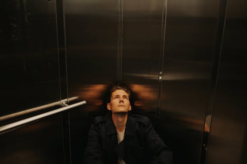 Man Looking Up sitting on Elevator