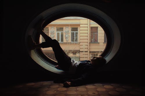 Man Lying in Round Window