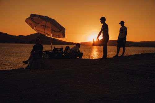 Free Silhouettes of people at a lakeshore with a sunset backdrop in Pertek, Türkiye. Stock Photo