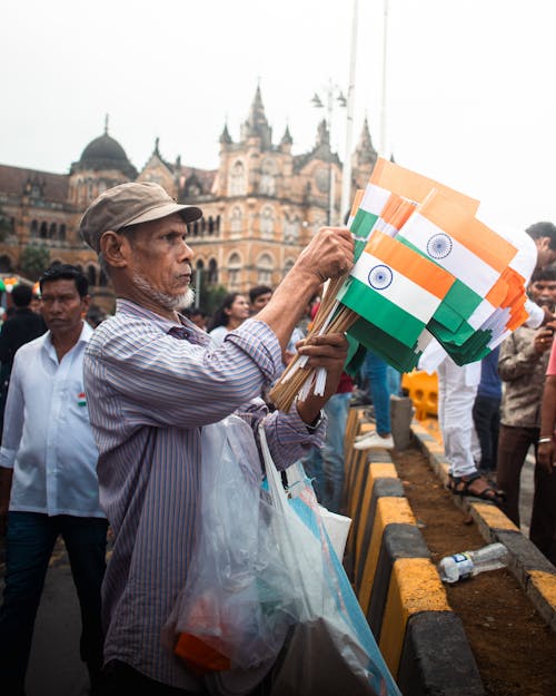 Man Holding Bunch of Indian Flags