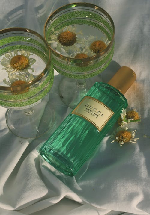Gucci Perfume near Flowers in Glasses