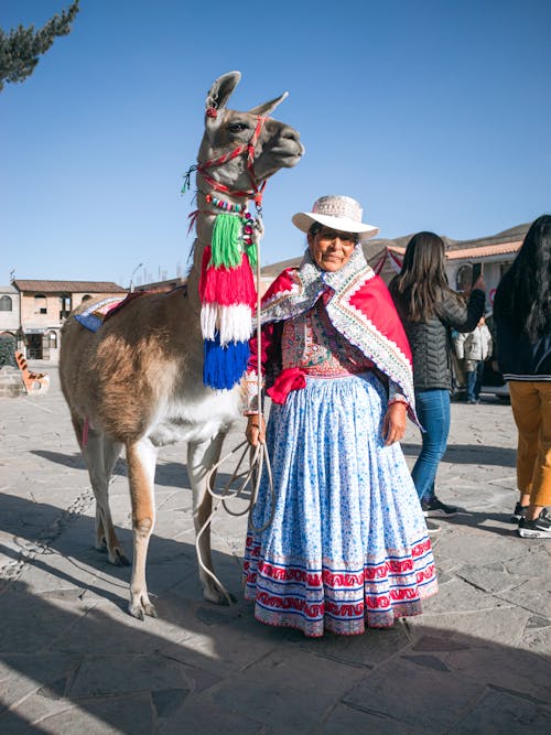 Woman in Traditional Clothing Standing with Llama