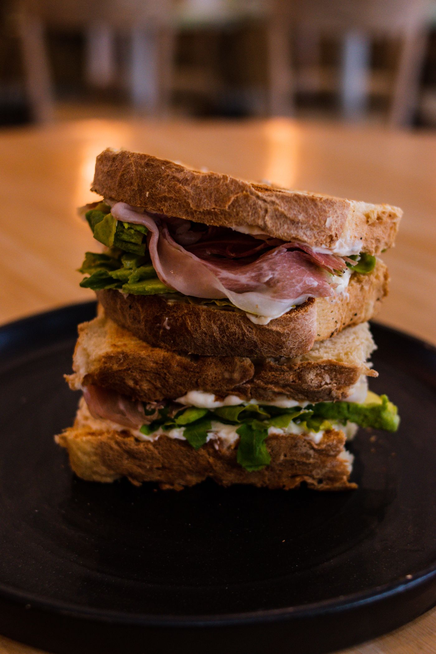 A freshly made sandwich stacked with ham and salad
