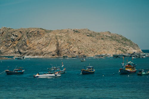 Motorboats Moored near Rocky Sea Shore