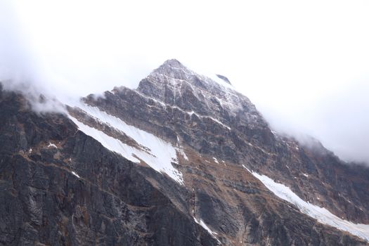 Breathtaking view of Mount Edith Cavell in Jasper National Park enveloped in fog.