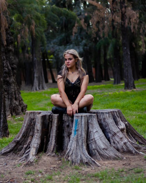 Woman Sitting on Tree Trunk