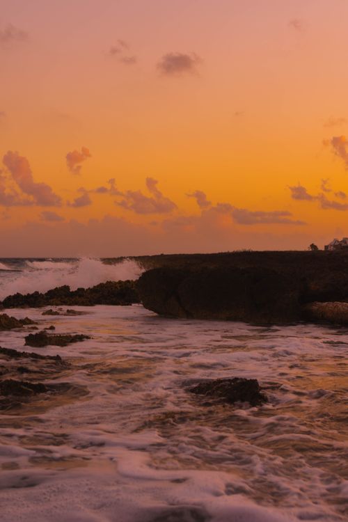 Free Breathtaking Akumal beach sunset scene with waves crashing against rocks. Stock Photo
