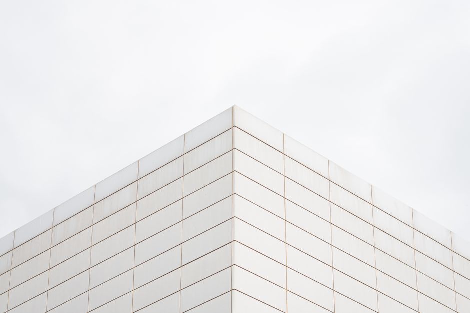 A minimalist architectural photo of a modern building corner with clean symmetry.