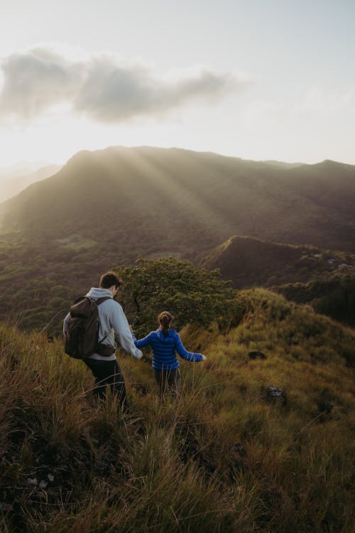 Man and Woman Hiking on Hills