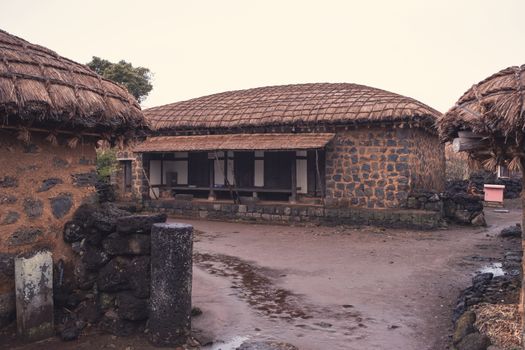 Capture of traditional stone houses with thatched roofs in a rural setting, exuding simplicity and historic charm.