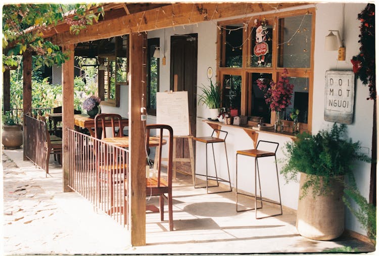 Exterior Of A Cafe With Chairs And Tables On The Porch 