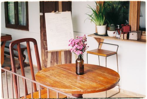 Free Rustic interior with a wooden round table and floral decoration in a cozy setting. Stock Photo
