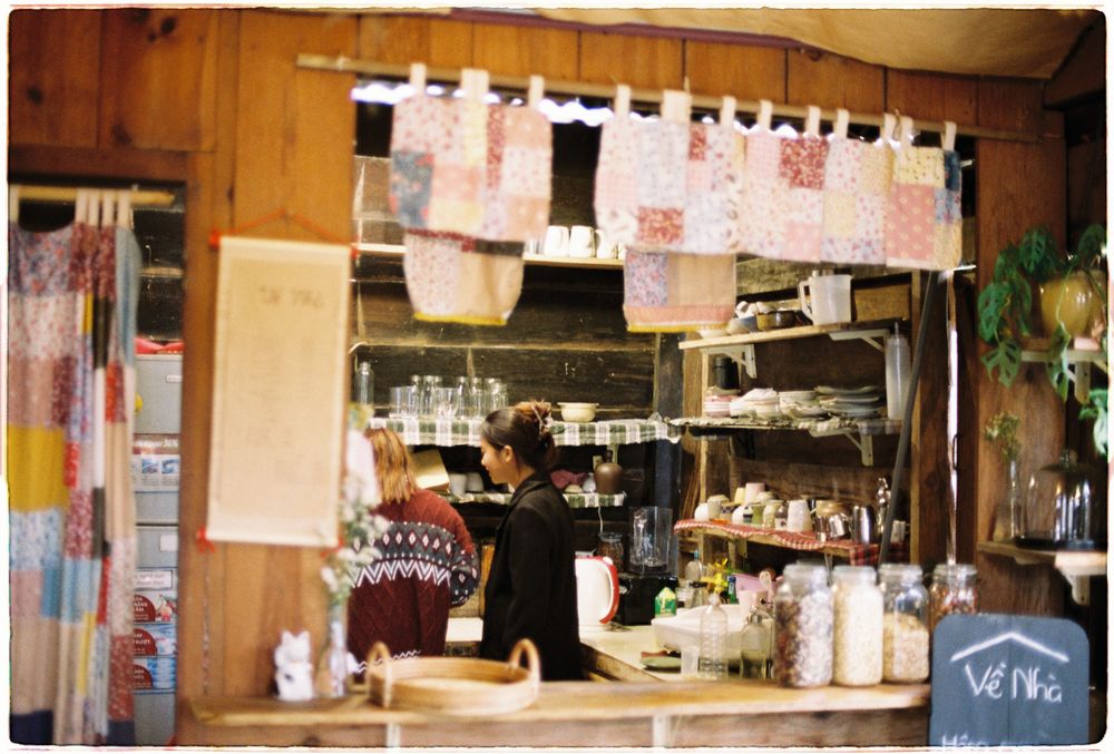 Dos personas trabajando en una cafetería con un ambiente cálido.