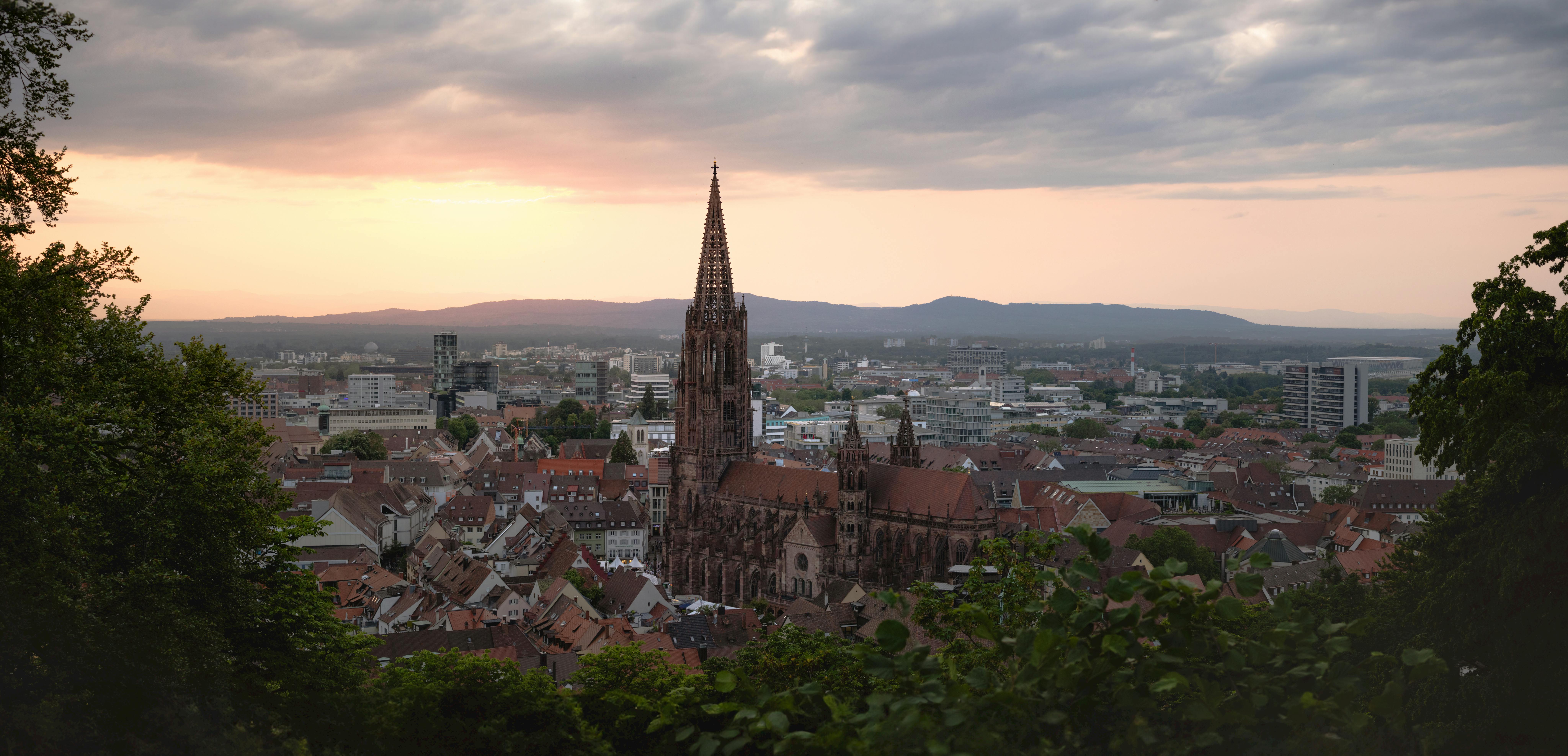 a view of a city at sunset with a church in the background