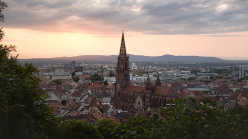 A view of a city at sunset with a church in the background