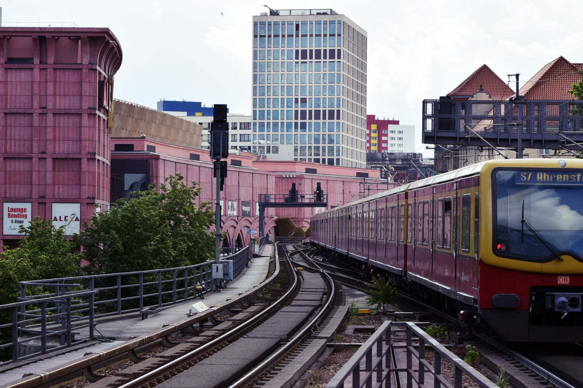 View of an S-Bahn train navigating through Berlin's urban landscape with colorful buildings.