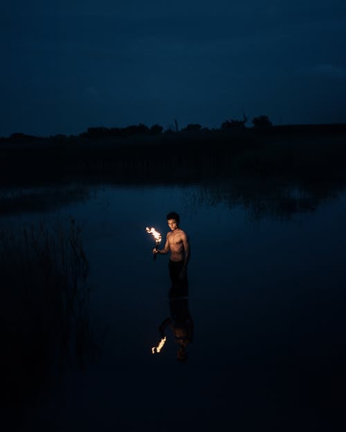 Man with Torch in Water at Night