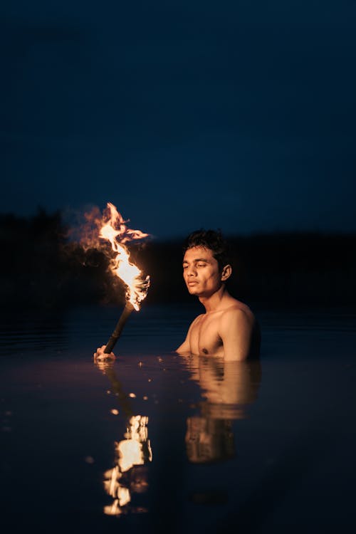 Man Standing in Water with Torch 