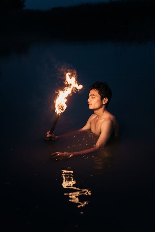 Man with Torch in Water at Night