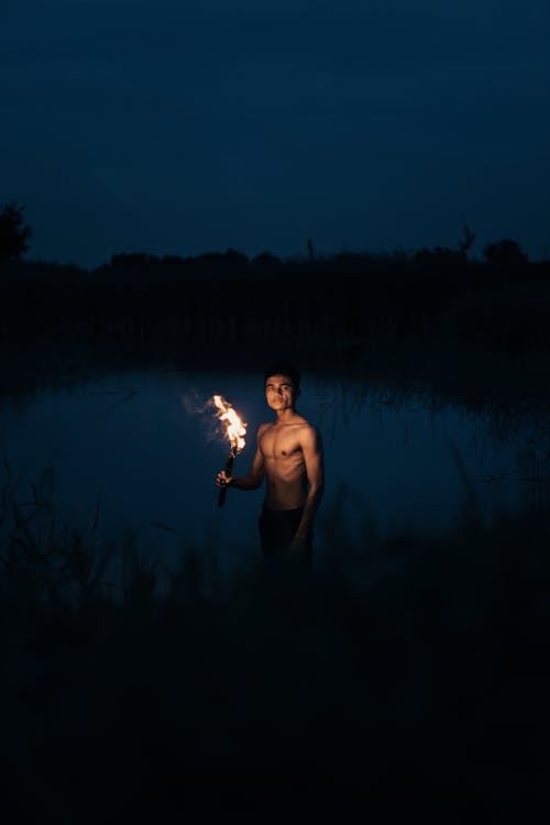 Topless Man with Torch at Night