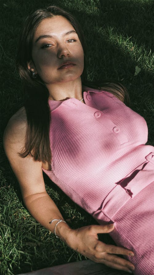 Model in a Pink Dress Lying on the Grass