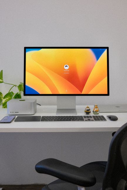 Fotomural Un elegante entorno de oficina que presenta un ordenador de escritorio, teclado y accesorios sobre un escritorio blanco limpio.