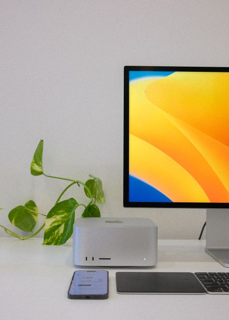 Fotomural Un espacio de trabajo elegante que presenta un monitor, un smartphone y un ordenador en una configuración minimalista.