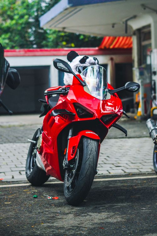 Free Close-up of a striking red motorcycle parked in an urban setting, showcasing modern design and vibrant color. Stock Photo