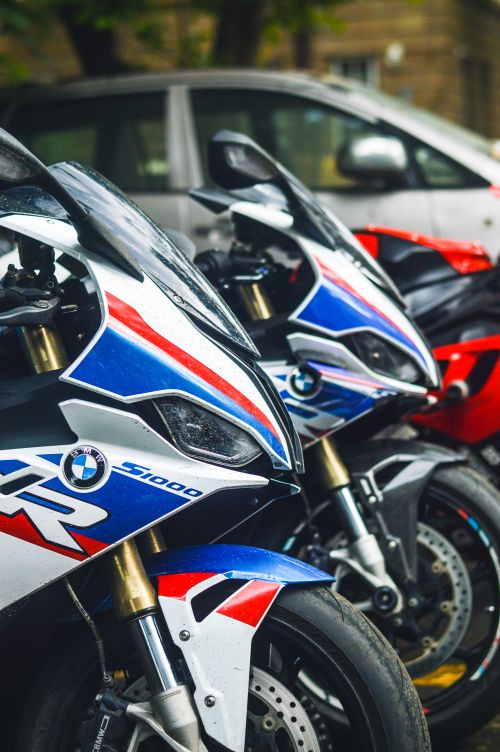 Free Detailed shot of BMW S1000 RR motorcycles with colorful liveries parked outdoors. Stock Photo