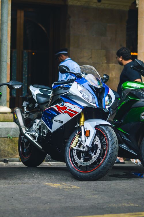Free High-performance sport motorcycle parked on city street with people nearby. Stock Photo