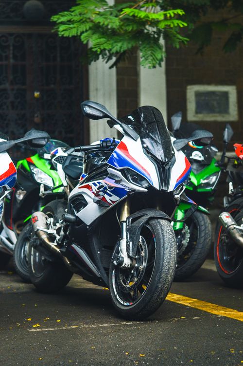 Free Motorbikes parked on a city street, showcasing sleek designs and vibrant colors. Stock Photo